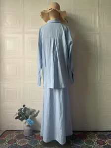 Back view of a women's light blue long-sleeved shirt and maxi skirt set on a mannequin.