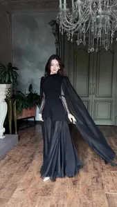 Elegant long-sleeved black evening gown with flowing cape sleeves and floor-length skirt.