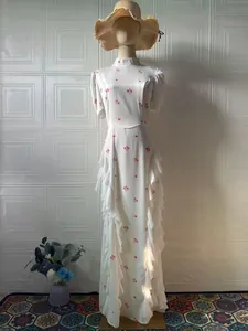 Elegant white long floral dress with side ruffles displayed on mannequin for spring