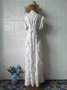 Back view of elegant white floral maxi dress with corset lace-up detail and side ruffles