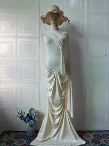 Detalle de vestido color marfil sin mangas con chal drapeado y dobladillo de sirena.