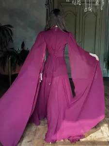 Elegant burgundy maxi dress with dramatic cape sleeves and corset-style lacing back.