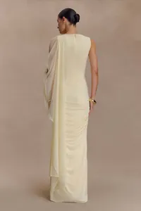 Vista trasera de elegante vestido de noche crema con detalle de capa drapeada hombro