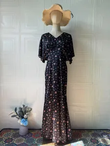 Elegante abito lungo nero a fiori con scollo a V presentato su un manichino sartoriale
