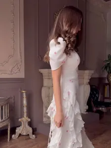 Elegant white floral maxi dress featuring a ruffled tiered skirt and puff sleeves