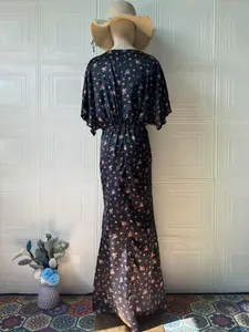 Vista posteriore di un elegante abito lungo vintage nero con stampa floreale rosa su manichino.