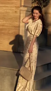 Elegante abito lungo a fiori con maniche a sbuffo in una scena all'aperto.