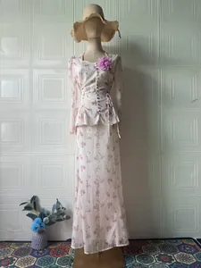Elegante set due pezzi floreale rosa con top a maniche lunghe e gonna lunga su manichino