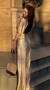 Modella che posa in un elegante abito lungo floreale vintage con maniche corte al tramonto