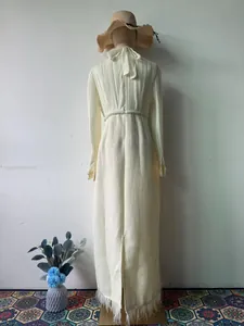 Achteraanzicht van elegante beige tweedjurk met geplooid lijfje en franjezoom