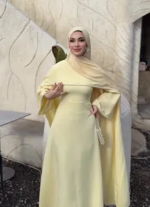Elegantes blassgelbes langärmliges Maxikleid mit Perlenbesatz und passendem Hidschab-Kopftuch