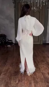 Detail van de elegante crème jurk met geplooide lantaarnmouwen en een strik op de rug