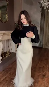 Elegante zwart-witte jurk in Hepburn-stijl met parelkraag en verenrand aan de zoom.