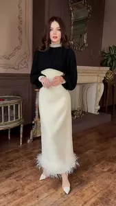 Elegante zwart-witte Hepburn-stijl jurk met parelkraag en veren aan de zoom.