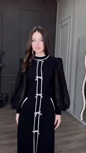 Robe longue noire élégante avec détails de nœuds blancs et manches bouffantes