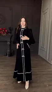 Robe longue noire élégante avec détails de nœuds blancs et col montant, style automnal chic.