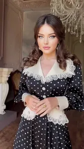 Detailed view of a vintage polka dot dress with an intricate lace doll collar design.