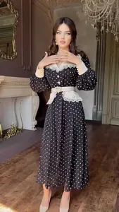 Close-up of vintage black polka dot dress featuring white lace collar and heart belt