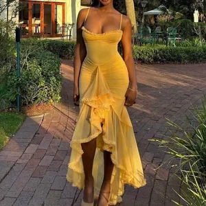 Detailed view of elegant yellow ruffled high-low hem sleeveless dress in sunlit garden