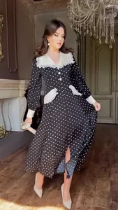 Elegant polka dot midi dress with detailed lace doll collar in a luxury indoor setting