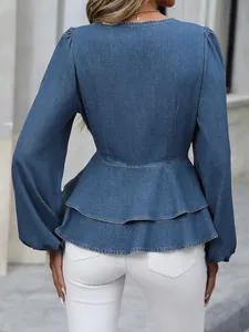 Back detail of blue denim long sleeve shirt with tiered peplum hem and slim fit.