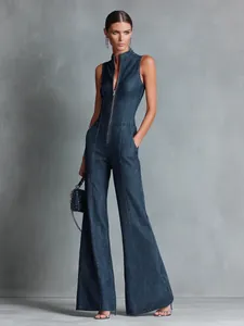 Professional model wearing a retro sleeveless deep blue denim jumpsuit with front zipper detail
