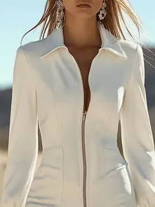 Gros plan d'une robe en denim blanc ajustée avec fermeture éclair et poches.