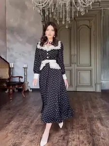 Elegant black long sleeve polka dot dress featuring a white lace doll collar and belt