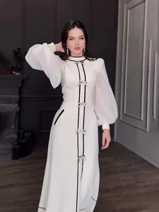 Robe longue blanche élégante avec bordure noire et nœuds argentés, col demi-montant