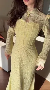 Close-up detail showing intricate lace on a yellow Victorian maxi dress with sleeves