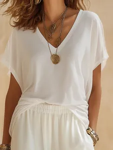 Dettaglio dell'elegante top bianco con scollo a V in tessuto leggero e strutturato