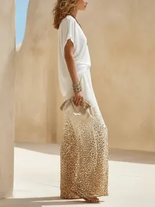 Dettaglio a figura intera di top bianco a V e pantaloni larghi con stampa leopardata