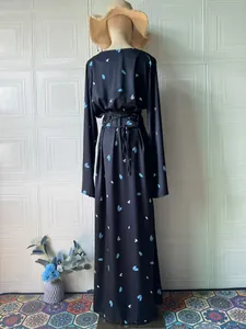 Rückansicht eines eleganten schwarzen Langarm-Maxikleids mit blauem Blumenmuster