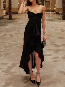 Elegant black spaghetti strap dress with asymmetric ruffled hem in high-end setting