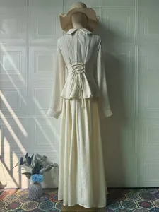 Back view of elegant cream long-sleeve dress featuring a corset-style lace-up waist