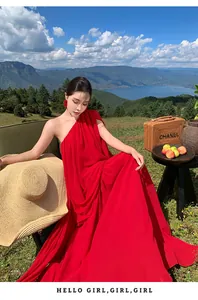 Elegant red one-shoulder pleated maxi dress shown in an outdoor scenic landscape