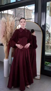Elegant burgundy long-sleeved maxi dress with cinched waist and beaded collar detail