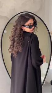 Detailed view of button accents on a minimalist black long-sleeved street fashion maxi dress.