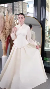 Elegant cream long-sleeved maxi dress with pleated sleeves and peplum waist detail