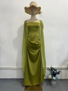 Gedetailleerde weergave van de olijfgroene avondjurk met elegante transparante sjaal en geplooide taille.