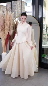 Elegant cream long-sleeved pleated maxi dress with waist-cinching corset detail