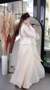 Elegant cream long-sleeved waisted maxi dress shown in a lifestyle mirror setting