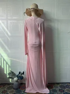 Vista trasera de un vestido maxi rosa de manga larga con elegantes detalles drapeados
