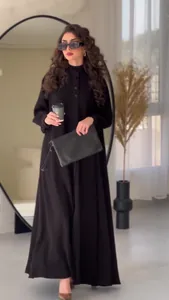 Elegant black maxi dress with long sleeves and button-down front in a modern interior
