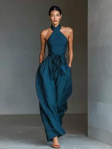 Elegant teal linen halter neck jumpsuit featuring cross straps and a wide leg fit on model