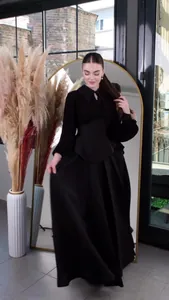Detail view of elegant black long-sleeved waist-cinching maxi dress for women