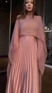 Elegante roze jurk met lange mouwen, verfijnde plooirok en een modieuze cape-overlay.