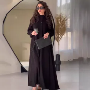 Elegant long-sleeved black maxi dress with button details and minimalist street style.