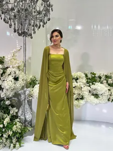 Elegante olijfgroene avondjurk met bijpassende sjaal in een bloemrijke studio-omgeving.