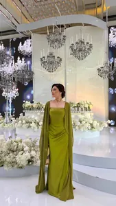 Elegante olijfgroene lange avondjurk met bijpassende cape in een luxe balzaal omgeving